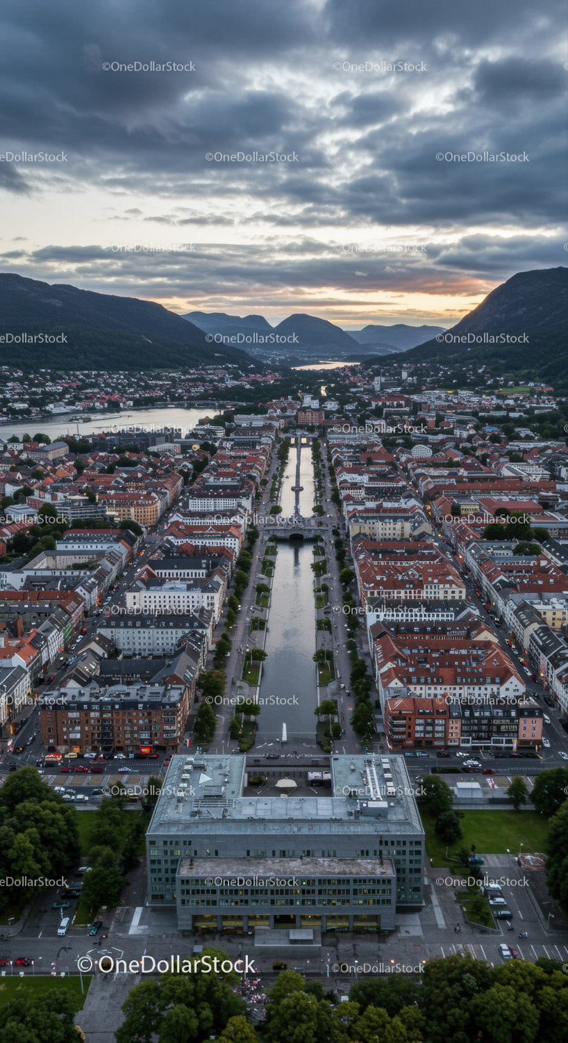 Scenic Mountain Town with River and Modern Buildings at Sunset
