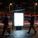 Illuminated Urban Bus Stop Sign at Night with Pedestrians
