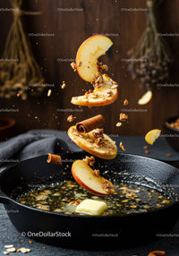 Sliced apples and cinnamon falling into hot butter