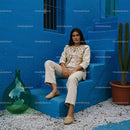Elegant Woman in Traditional Attire Against a Vibrant Blue Wall