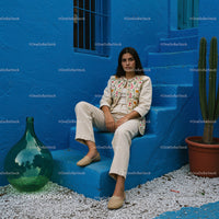 Elegant Woman in Traditional Attire Against a Vibrant Blue Wall