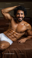 Smiling muscular man relaxing on bed in white underwear