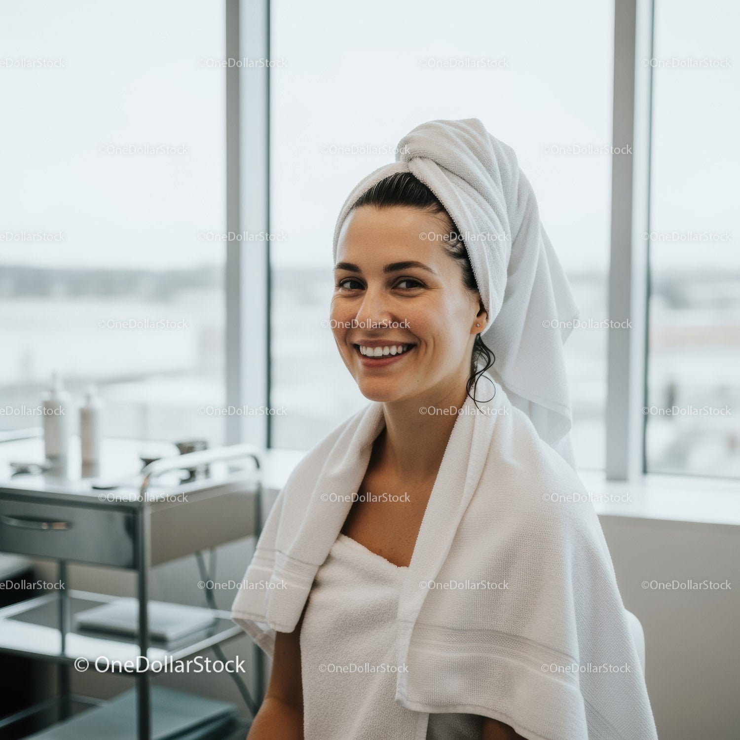 Uśmiechnięta kobieta z turbanem w ręczniku w centrum relaksu Spa