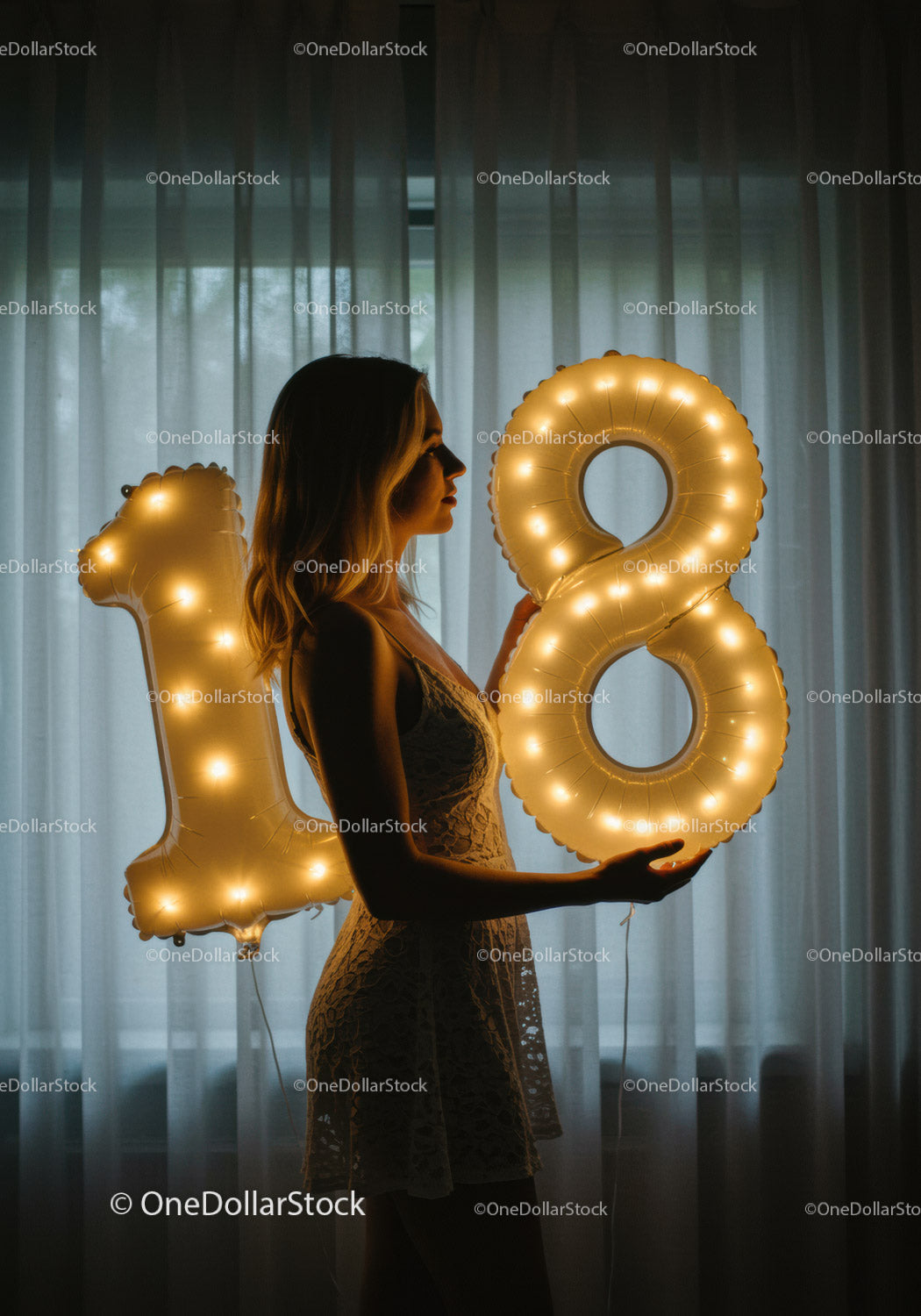 Young woman celebrating eighteenth birthday with glowing balloons