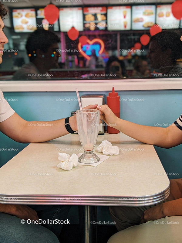Couple Holding Hands Across Table in Vintage Diner