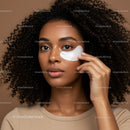 Young Woman with Curly Hair Applying Face Mask with Skincare Product