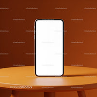 Modern smartphone with blank screen on orange table