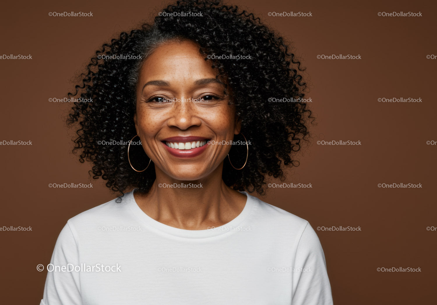 Portrait of a Smiling Woman with Curly Hair and Hoop Earrings on Warm Background