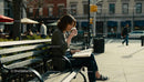 Young woman enjoying coffee and reading in urban park