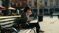 Young woman enjoying coffee and reading in urban park