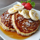Banana and Strawberry Topped Pancakes with Maple Syrup and Fresh Fruit