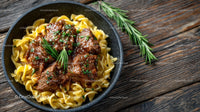 Hearty Beef Stew over Pasta with Fresh Herb Garnish