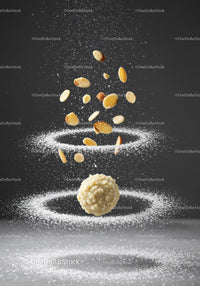 Chocolate truffle surrounded by flying almond slices and sugar