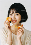 Smiling Woman with Short Black Hair Holding Slices of Fresh Tangerine