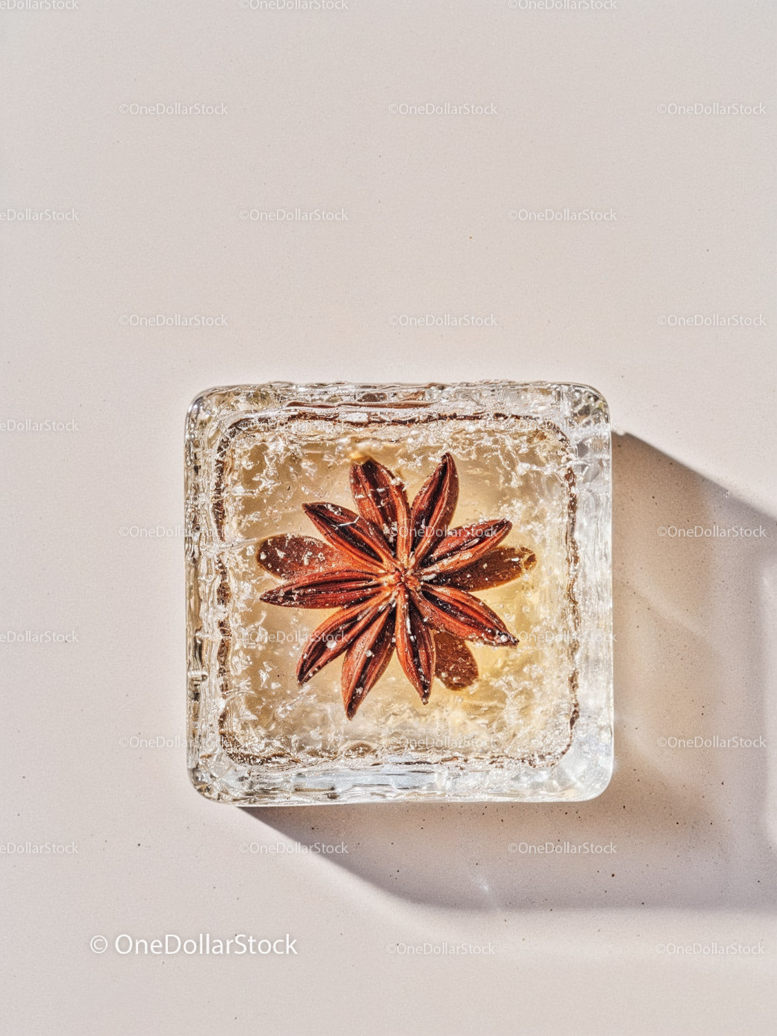 Star Anise Embedded in Clear Ice Cube on White Surface