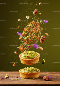 Pistachio tarts with flying nuts and caramel decoration