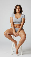 Young Woman Sitting on Stool in Casual Outfit with Confident Expression