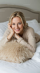 Smiling woman relaxing on bed with cozy pillow