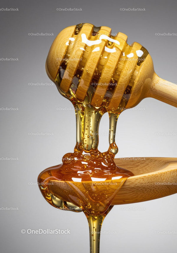 Golden honey dripping from wooden dipper to spoon