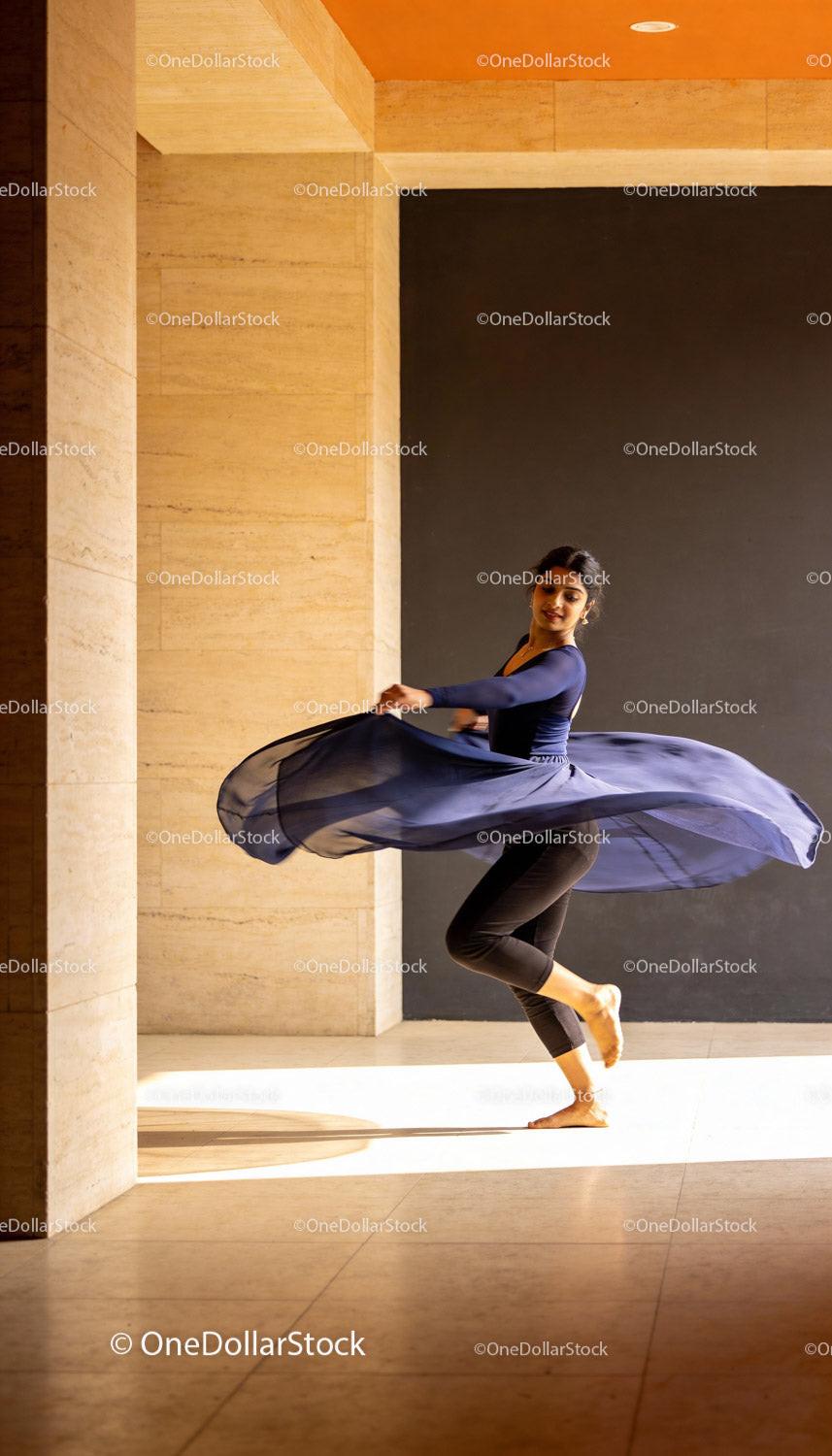 Graceful female dancer twirling in airy blue skirt