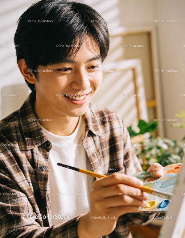Young man joyfully painting with bright colors indoors