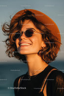Young Woman Wearing Stylish Orange Fedora and Sunglasses Outdoors