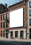 Urban brick building with large blank billboard and bicycles