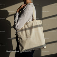 Person Holding Blank Canvas Tote Bag Over Shoulder