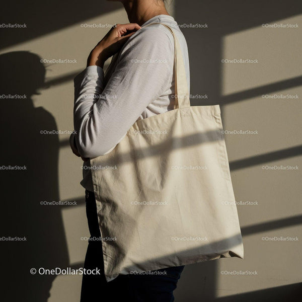Person Holding Blank Canvas Tote Bag Over Shoulder JPG Mockup Image