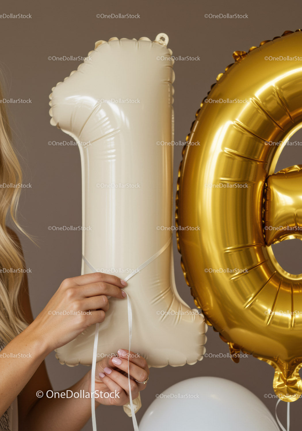 Kobieta trzymająca eleganckie beżowe i złote balony z cyframi
