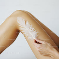 Elegant Woman Holding White Feather on Smooth Skin with Soft Lighting