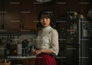 Elegant Woman Standing in Modern Kitchen During Daylight