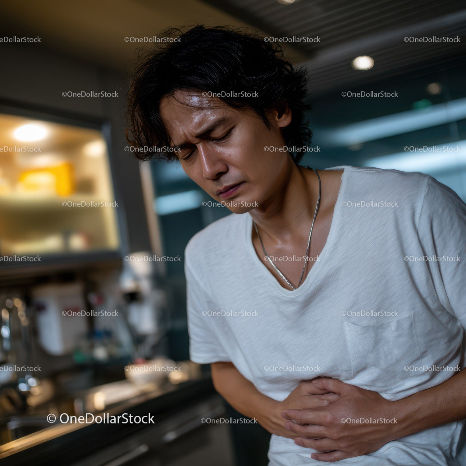 Young Man Experiencing Stomach Pain in Modern Indoor Setting