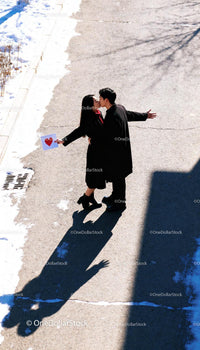 Couple sharing a kiss with love letter on snowy street