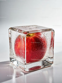 Red apple encased in clear glittering ice cube