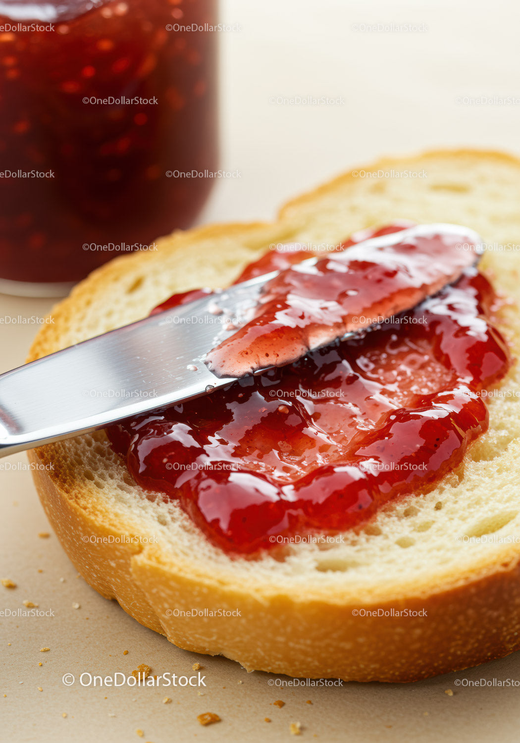 Spreading fresh strawberry jam on soft white bread