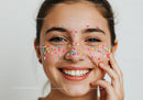 Playful Young Woman with Colorful Sprinkles on Face in Bright Portrait