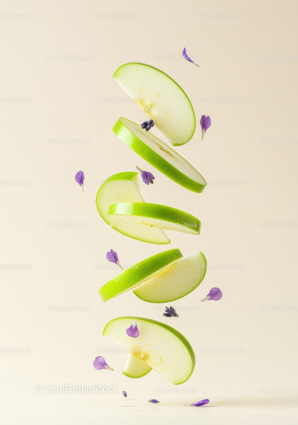 Floating green apple slices with delicate purple flowers