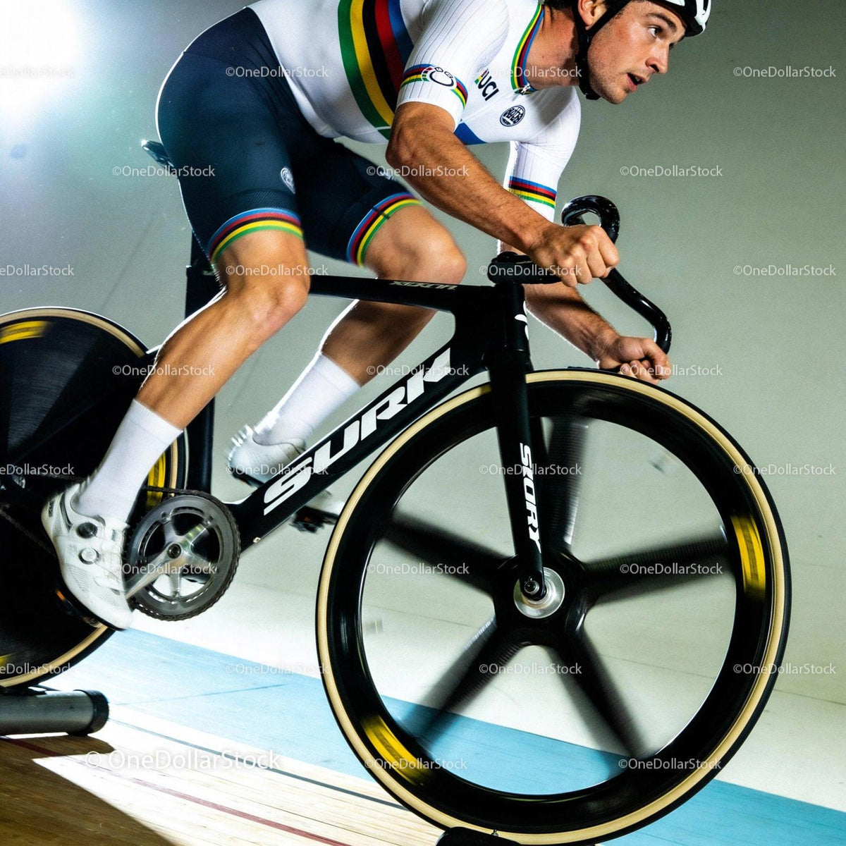 Focused cyclist pedaling intensely on racing bike indoors