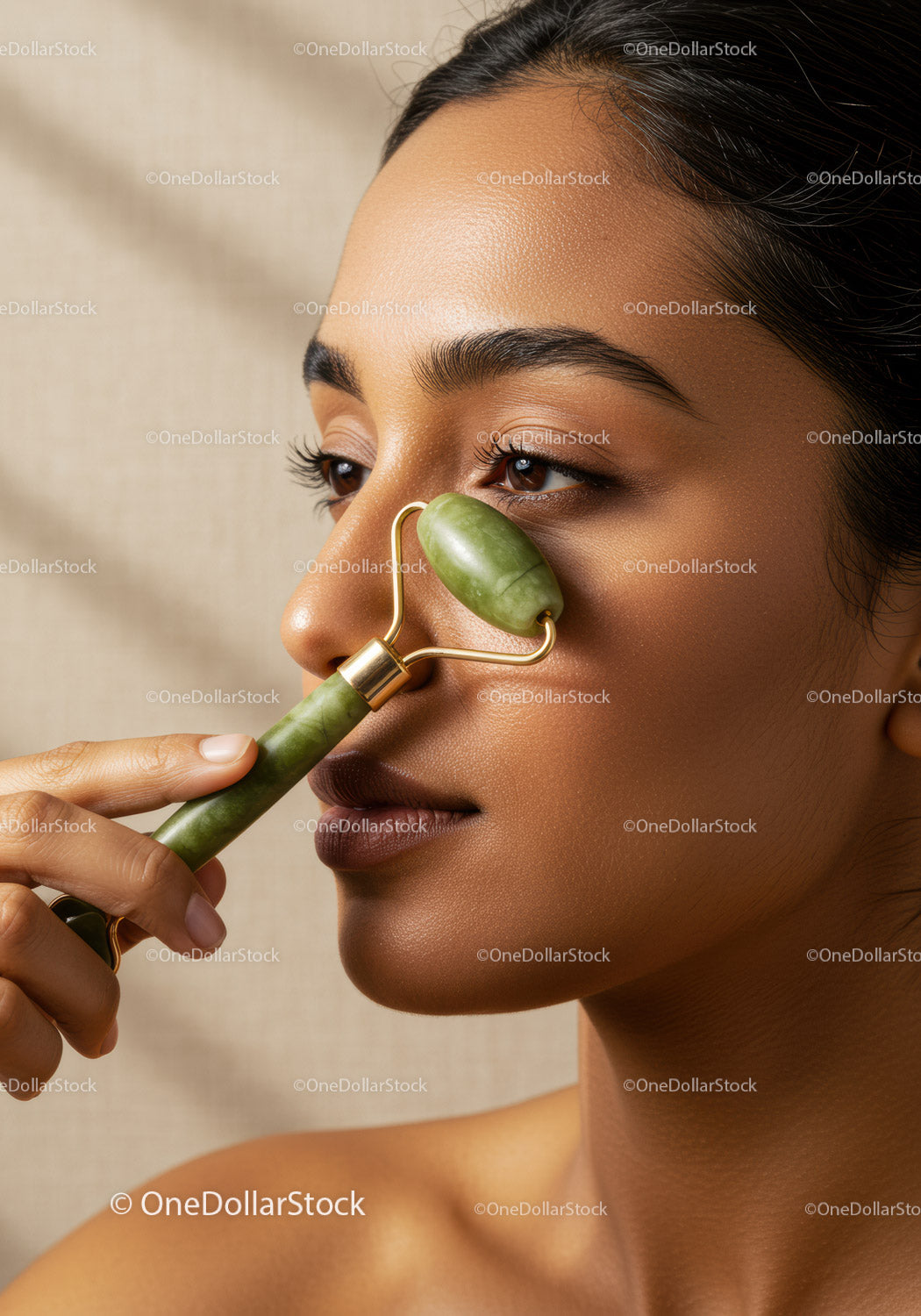Close-up of a woman using a jade facial roller for skincare and facial massage