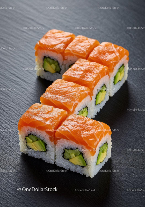 Fresh salmon sushi rolls with avocado on black plate