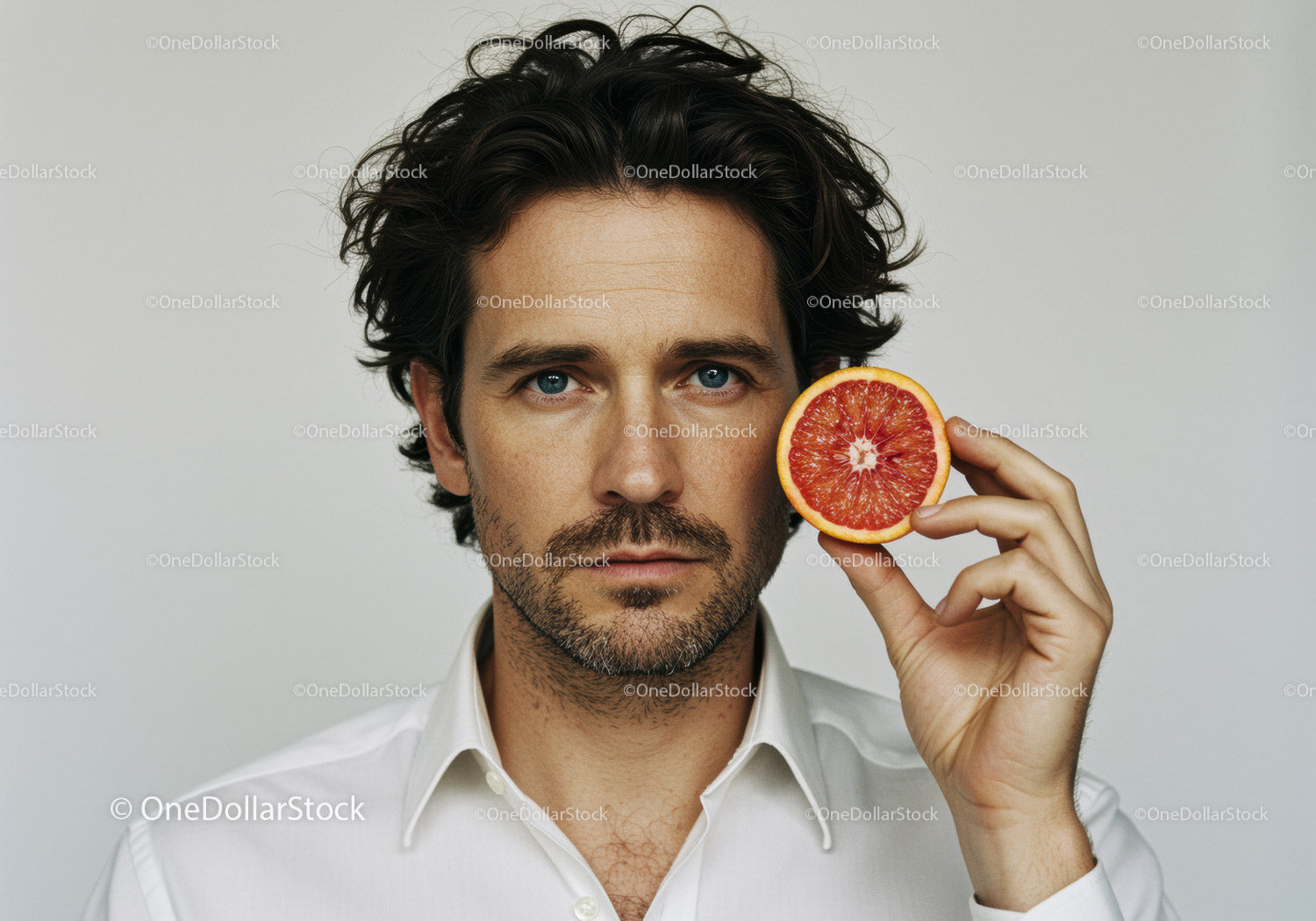 Male Portrait with Grapefruit in Bright Minimalist Setting