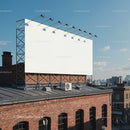 Empty billboard on rooftop above urban brick building