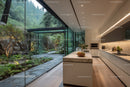 Modern Kitchen with Floor-to-Ceiling Glass Walls and Scenic Garden View