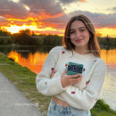 Young woman enjoying fresh blueberries by lake at sunset