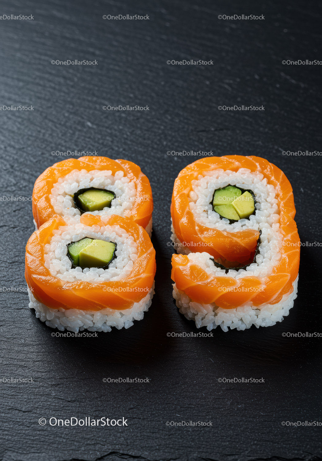 Rolki sushi z łososiem i awokado na czarnym talerzu łupkowym