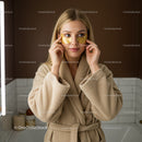 Relaxing Woman Applying Eye Masks in Cozy Spa Setting