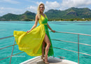 Elegant Woman in Yellow and Green Dress on Yacht at Scenic Ocean