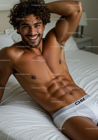 Smiling muscular man relaxing on bed in white underwear