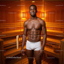 Healthy Young Man Relaxing in Sauna Room With Warm Wooden Interior